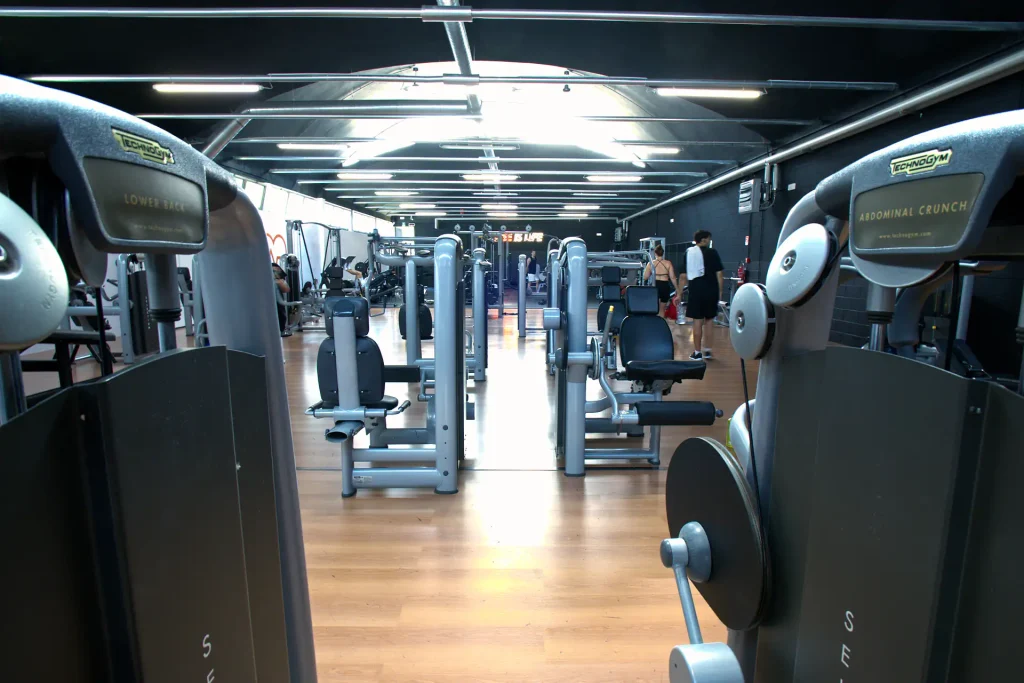 Macchine isotoniche Technogym Lower Back e Abdominal Crunch in primo piano nella sala attrezzi di ViBE Fitness Arosio.