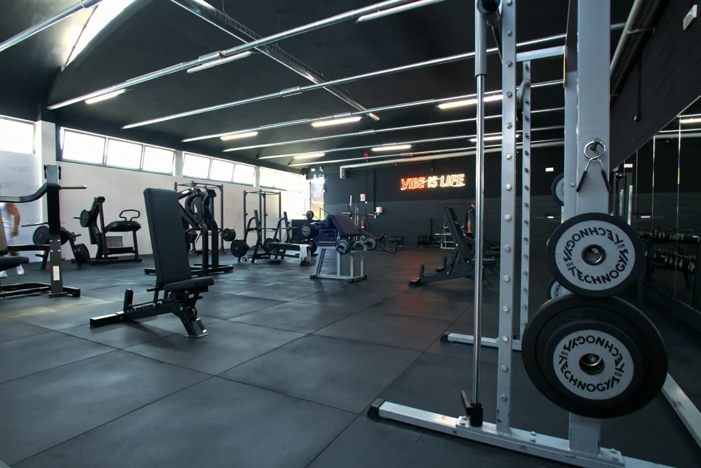 Zona pesi liberi e rack con dischi Technogym, pavimentazione gommata antishock e neon 