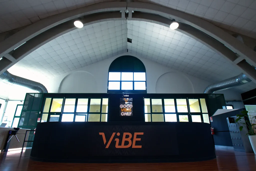 Reception e bancone principale di ViBE Fitness Barlassina con il logo illuminato 